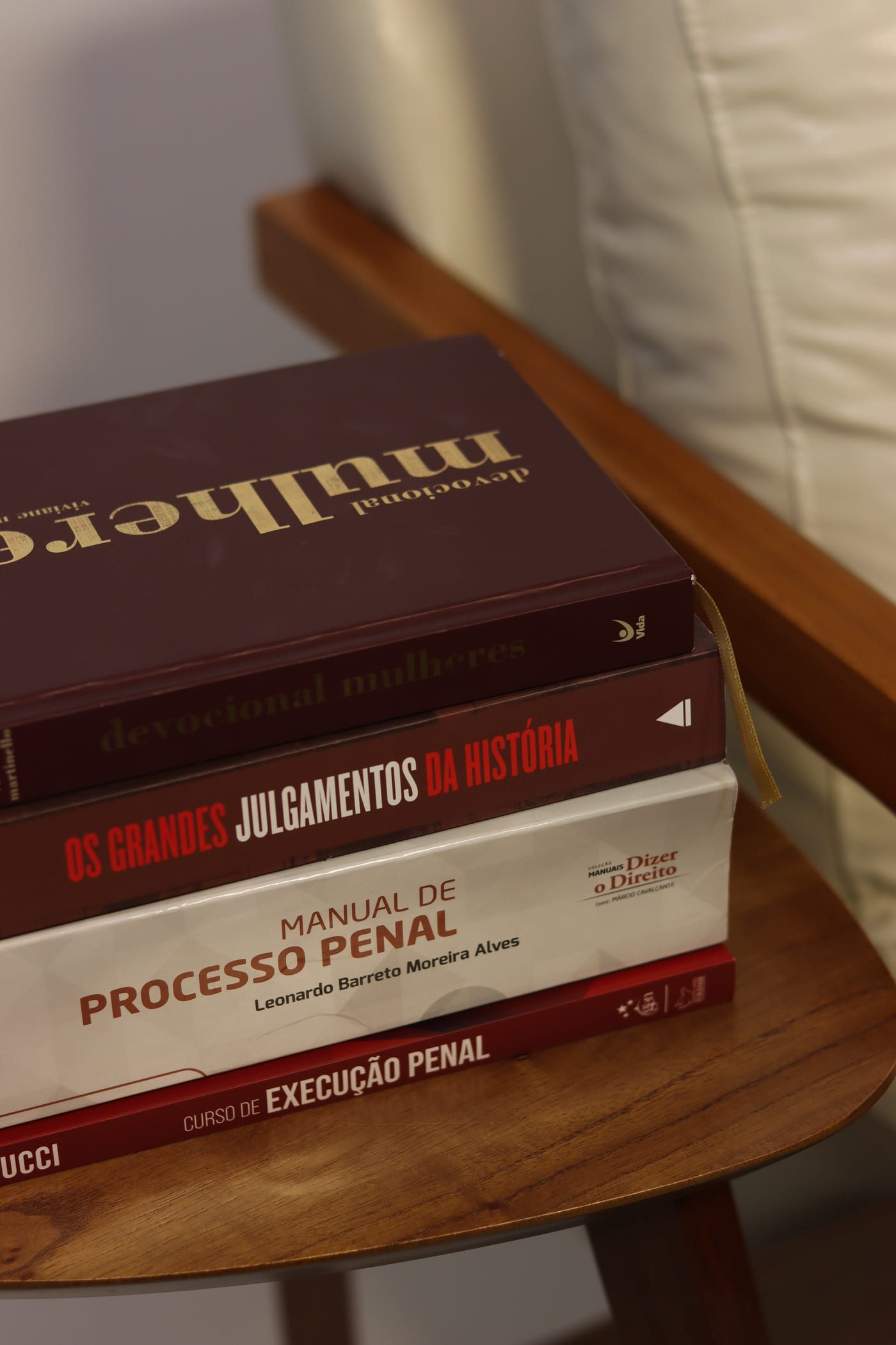 Pilha de obras de processo e execução penal sobre a mesa lateral do escritório
